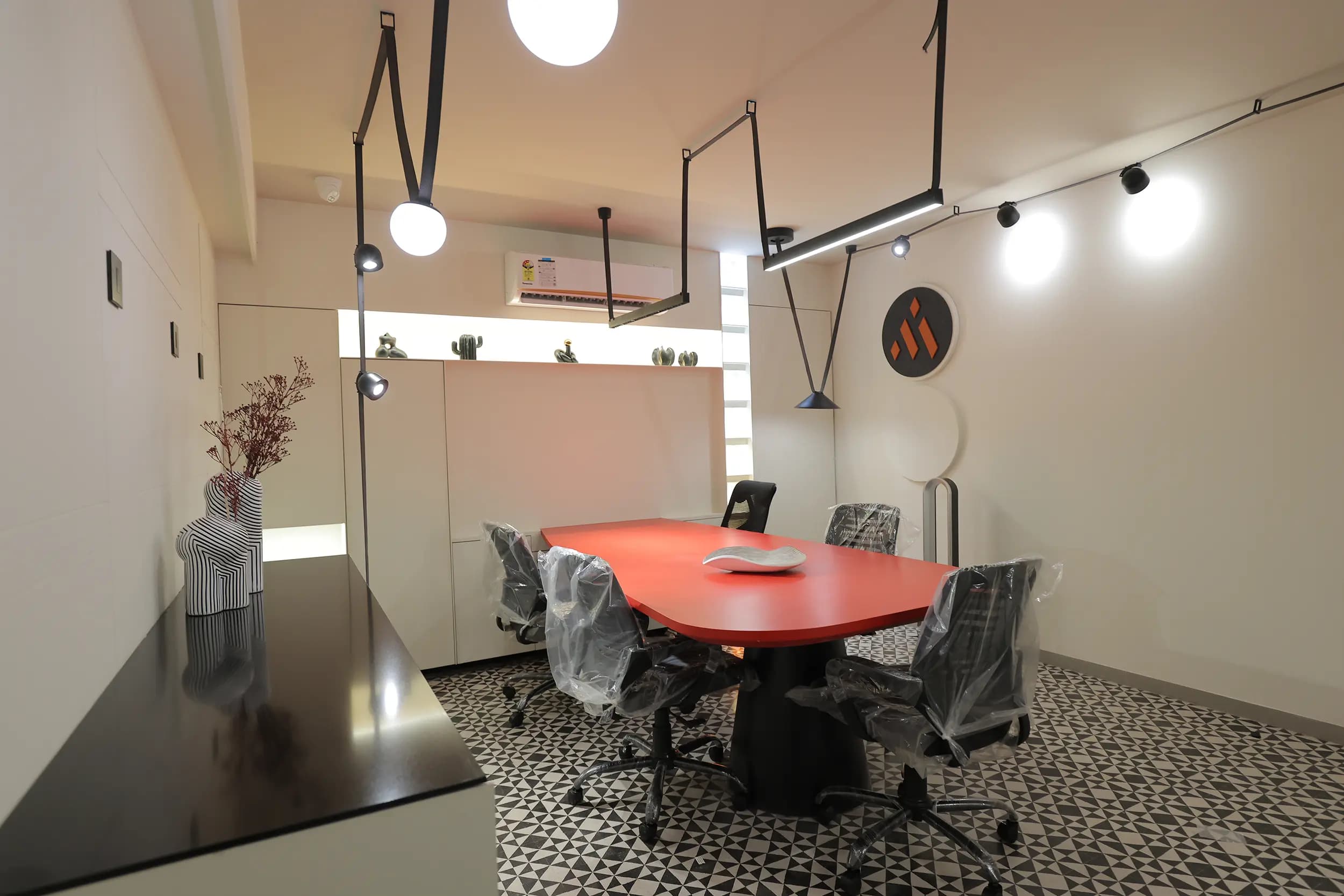 Meeting space showing architectural track and pendant lighting