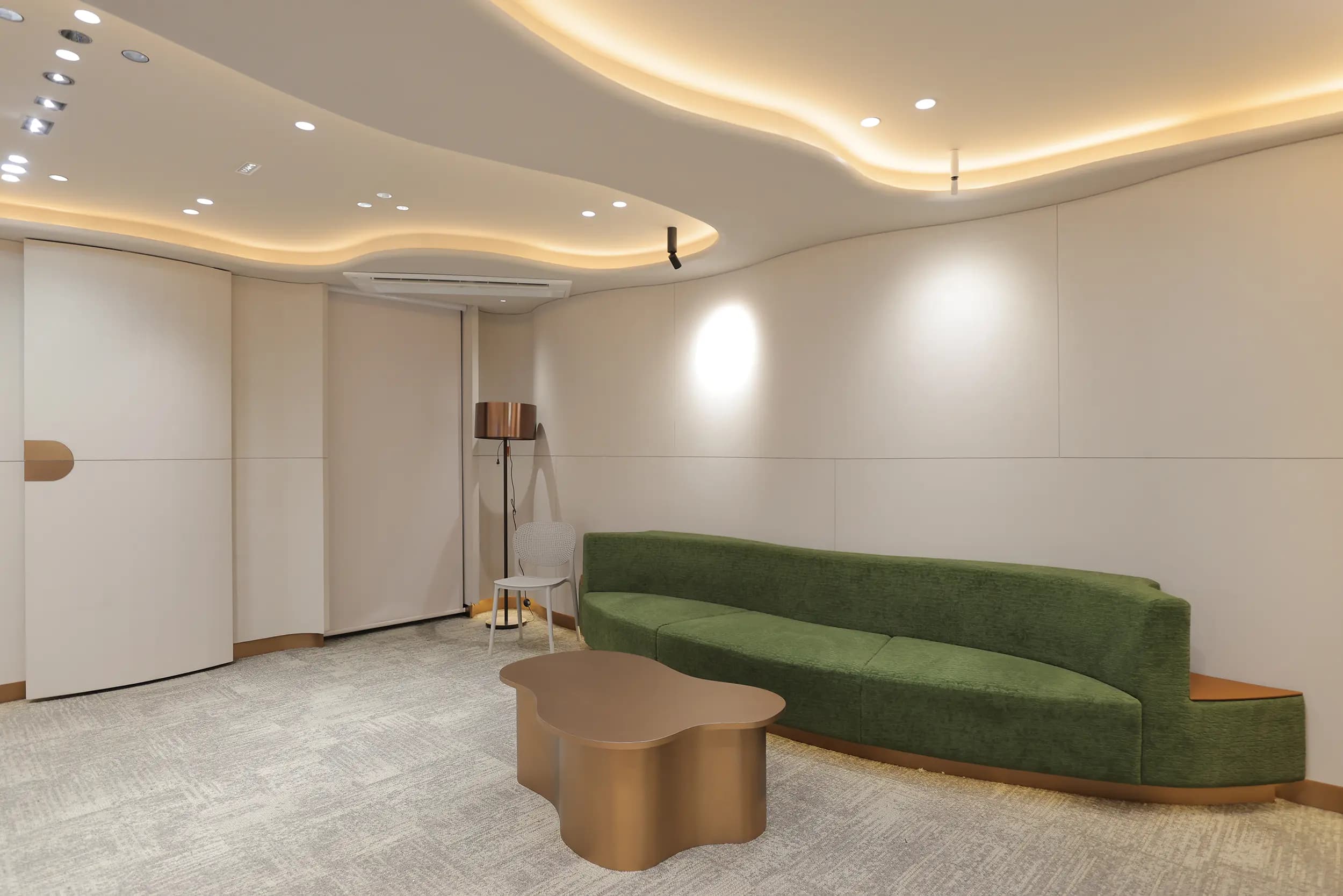 Lounge seating beneath a sculpted, cove-lit ceiling